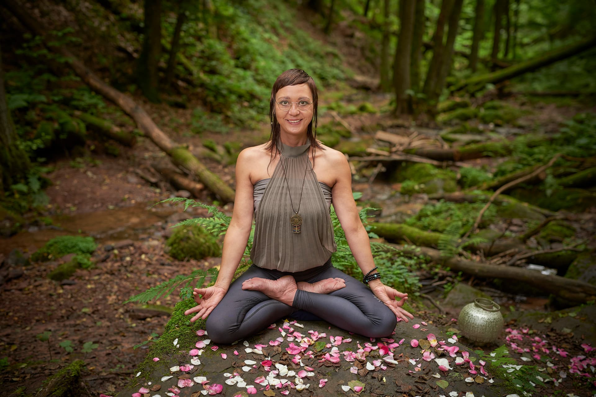 Nadine Geiger in einer ruhigen Yogahaltung im Wald.