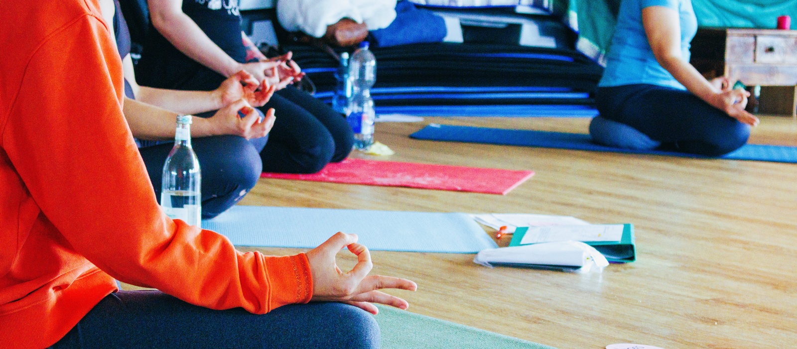 Teilnehmerinnen üben Mudras während eines Yogaseminars